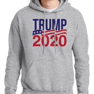 May include: A grey hooded sweatshirt with the text "TRUMP 2020" in red and blue lettering. The text is overlaid with a red, white and blue American flag design.