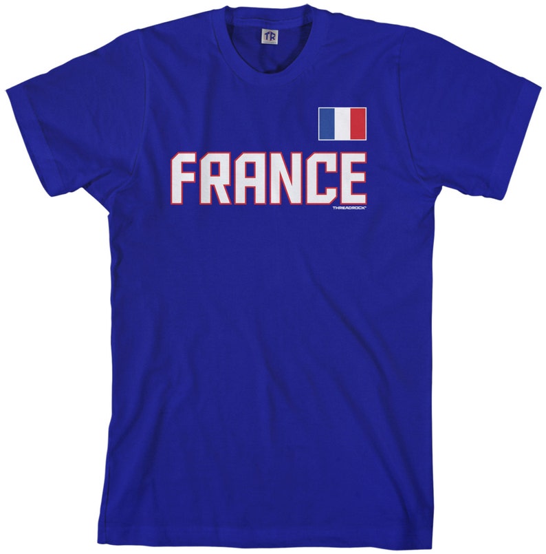 May include: A royal blue t-shirt with the word "FRANCE" in white letters outlined in red. A small French flag is above the word.