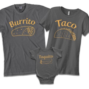 May include: A set of three gray t-shirts with a food theme. The adult shirts say "Burrito" and "Taco" with illustrations of the food. The baby shirt says "Taquito" with an illustration of a taquito.