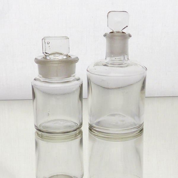 Pair vintage miniature apothecary jars.  Clear Glass.  Ground glass neck stoppers. Perfume, scent. 10 cms(4") and 8 cms (3") tall. Ex con