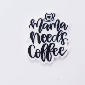 May include: Black and white sticker with the text "Mama needs coffee" and a small coffee cup with a heart in it.