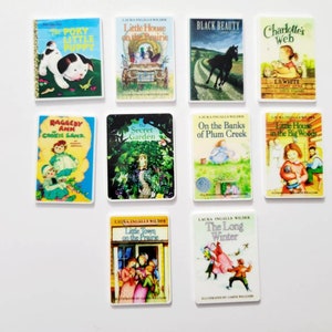 Puede incluir: Una colecci&oacute;n de 10 portadas de libros en miniatura que presentan t&iacute;tulos cl&aacute;sicos de literatura infantil, que incluyen "The Poky Little Puppy", "Little House on the Prairie", "Black Beauty", "Charlotte's Web", "Raggedy Ann", "The Secret Garden", "On the Banks of Plum Creek", "Little House in the Big Woods", "Little Town on the Prairie" y "The Long Winter".