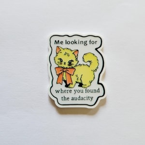 May include: A yellow cat sticker with an orange bow and the text "Me looking for where you found the audacity" in a black outlined white speech bubble.
