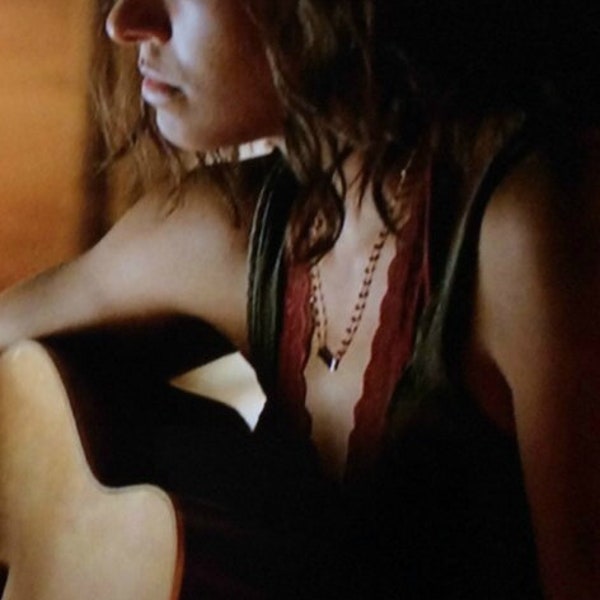 Comme on le voit dans The Vampire Diaries, connecteur en onyx noir sur un collier enveloppé de fil de grenat, porté par Bonnie (Kat Graham), saison 8, épisode 802