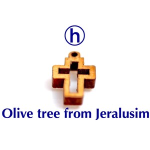 May include: A small wooden cross made from olive wood from Jerusalem. The cross is a simple design with a hole at the top for hanging.