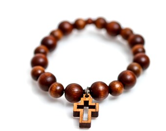 May include: A brown wooden beaded bracelet with a wooden cross charm.