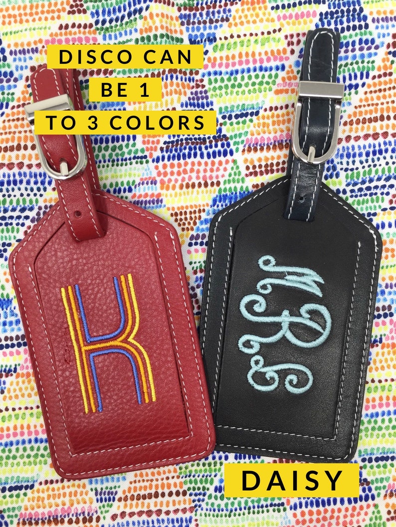 May include: Two rectangular luggage tags with adjustable straps and silver buckles. One tag is red with a yellow and blue embroidered letter K. The other is black with a light blue embroidered monogram. Text reads DISCO CAN BE 1 TO 3 COLORS DAISY.