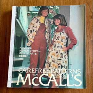 May include: A vintage magazine cover featuring two women modeling 1970s fashion. The cover includes the text "SUMMER NEVER STOPS... FALL STARTS HERE!" and "CAREFREE PATTERNS from McCALL'S". The models are wearing jumpsuits and dresses.