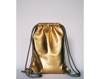 Premium Italian kid leather drawstring backpack in gold.