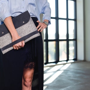 Young woman model is holding leather and felt laptop bag.