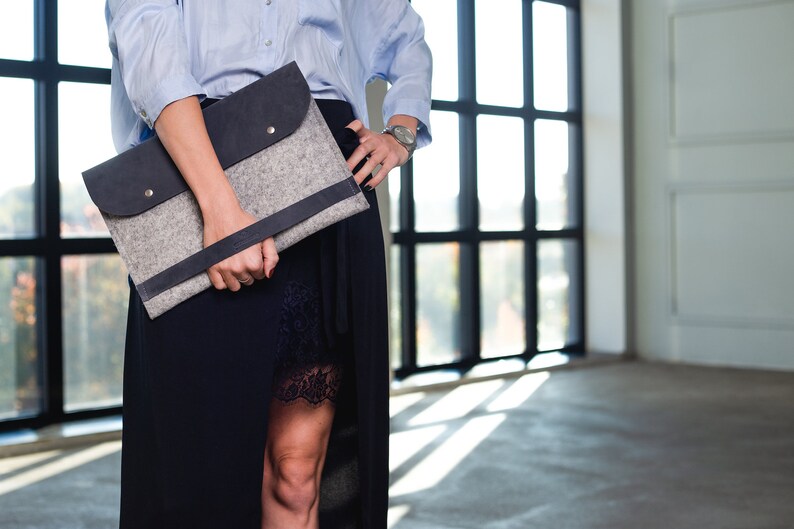 Young woman model is holding leather and felt laptop bag.