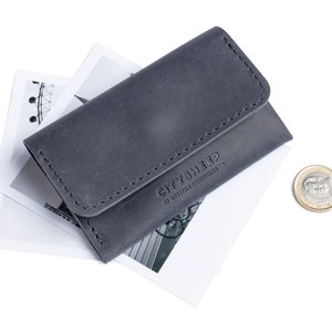 Gray leather wallet with logo CITYSHEEP. There is a coin near it.