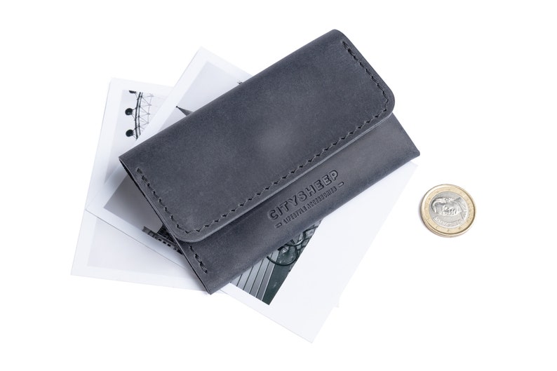 Gray leather wallet with logo CITYSHEEP. There is a coin near it.