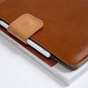Leather MacBook Sleeve with loop for a pen. Designed to fit MacBooK Air 13, MacBook Pro 13", MacBook Pro 14", MacBook Air 15. This MacBook sleeve is sleek, stylish and  gives your MacBook Top Protection.