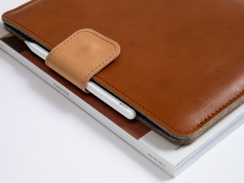 Leather MacBook Sleeve with loop for a pen. Designed to fit MacBooK Air 13, MacBook Pro 13", MacBook Pro 14", MacBook Air 15. This MacBook sleeve is sleek, stylish and  gives your MacBook Top Protection.