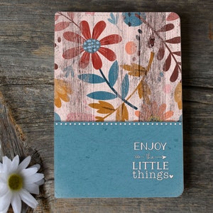 以下が含まれることがあります： 青い花柄とピンクの花柄のノート。表紙に「ENJOY -the- LITTLE things」の文字が書かれている。