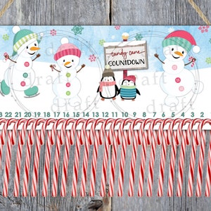May include: A Christmas countdown advent calendar with a blue background featuring three snowmen and two penguins. The calendar has 24 candy canes hanging from the bottom, each with a number printed on it. The text "Candy Cane Countdown" is printed on a sign held by the penguins.
