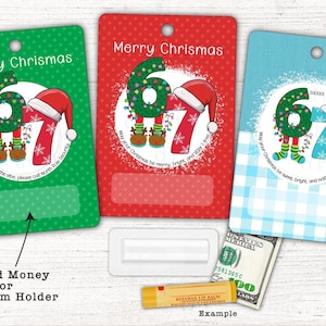 May include: Three Christmas gift tags in green, red, and blue, each with the text "Merry Chrismas." The tags feature a whimsical design of the numbers "67" dressed as elves with Santa hats. A rolled bill and lip balm are shown as examples.