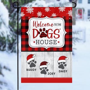 May include: A red and black plaid Christmas garden flag with the text "Welcome to the Dogs' House" and three paw prints with the names Buddy, Zoey, and Daisy.