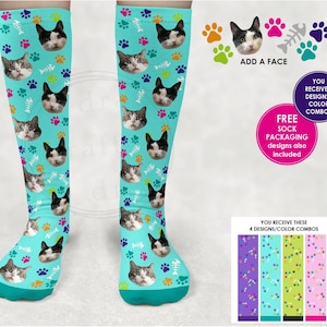 Könnte beinhalten: Ein Paar Kniestrümpfe mit türkisfarbenem Hintergrund und einem sich wiederholenden Muster aus weißen Pfotenabdrücken, Fischgräten und einem Katzenkopf. Die Socken sind mit einem Foto Ihrer Katze personalisierbar. Der Text "ADD A FACE" ist im Bild sichtbar. Sie erhalten vier Designs und Farbkombinationen.