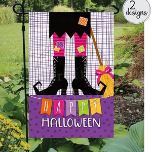 May include: A purple and white garden flag featuring a witch's legs wearing black boots and a pink and green striped skirt. The witch's legs are holding a broom with a yellow bow. The flag displays the words "Happy Halloween" in colourful letters.