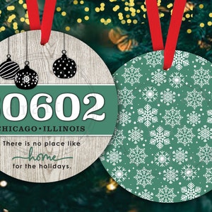 May include: Two round Christmas baubles. One bauble is green with a white snowflake pattern. The other bauble is wood-grain with a green background and white text that reads "60602 CHICAGO ILLINOIS There is no place like home for the holidays."