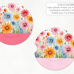 May include: Two car coasters with a watercolor floral design. The coasters feature a vibrant array of colorful flowers in shades of pink, orange, yellow, and blue. The bottom half of each coaster is a solid pink color. Text on the image reads "CAR COASTERS".