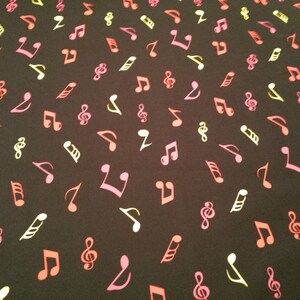 May include: Black fabric with a repeating pattern of colourful musical notes. The notes are in shades of pink, yellow, and red.
