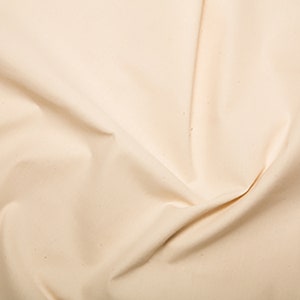 May include: A close-up of a smooth, off-white fabric with a subtle texture. The fabric is folded and draped, creating soft folds and curves.