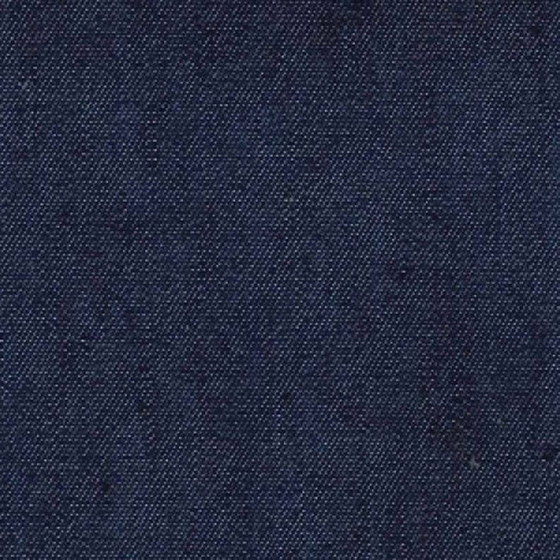 Op de afbeelding: Een close-up van een donkerblauwe denim stof. De stof heeft een geweven textuur en een glad oppervlak.