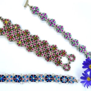 May include: Three beaded bracelets with silver clasps. The top bracelet is pink, green, and purple. The middle bracelet is pink, green, and black. The bottom bracelet is blue, pink, and black.