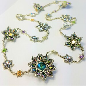 Peut inclure: Un collier de perles argentées avec des breloques en forme d'étoile irisées. Le collier présente une variété de couleurs, notamment le vert, le bleu, le violet et le jaune.