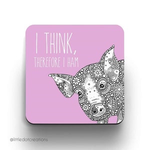May include: Pink square coaster featuring a black and white illustration of a pig's face with a floral pattern. The text "I think, therefore I ham" is written in black on the coaster.