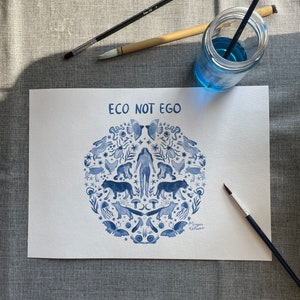 May include: A blue and white watercolor illustration of a circle with a woman in the center surrounded by animals, plants, and other natural elements. The text "ECO NOT EGO" is at the top of the circle. The artist's signature is at the bottom of the circle.