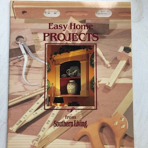May include: A book cover with the title "Easy Home Projects" from Southern Living. The cover features a photo of a wooden shelf with a vase and other decorative items, surrounded by woodworking tools.