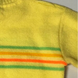 May include: Yellow sweater with green, orange, and yellow stripes.