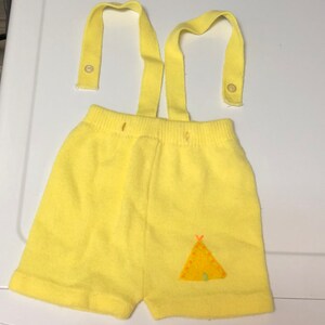 May include: Yellow knit shorts with suspenders and a small embroidered teepee design.