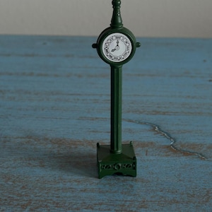 May include: A white ceramic mug with a black handle and the text "But First, Coffee" in a bold, black font. The mug is sitting on a wooden surface. The mug is approximately 4 inches tall.