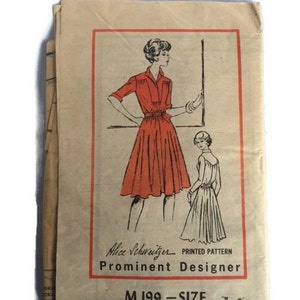 May include: Vintage sewing pattern for a dress, featuring a line drawing of a woman wearing a red dress with a belt. The pattern is labeled "Alice Schnitzer - Printed Pattern - Prominent Designer - M 199 - Size 14".