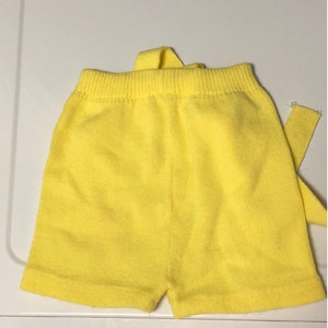 May include: Yellow knit shorts with a tie at the waist.
