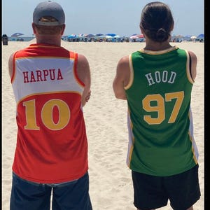 Puede incluir: Dos camisetas sin mangas vistas desde atr&aacute;s. La camiseta de la izquierda es roja y blanca con el texto HARPUA y el n&uacute;mero 10 en amarillo. La de la derecha es verde y blanca con el texto HOOD y el n&uacute;mero 97 en amarillo. Ambas tienen ribetes deportivos.