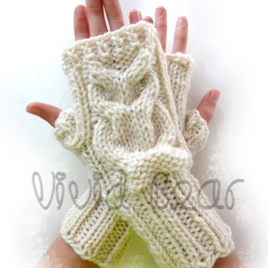 May include: A pair of cream-colored knitted fingerless gloves with a cable knit pattern. The gloves have a decorative design on the back of the hand.
