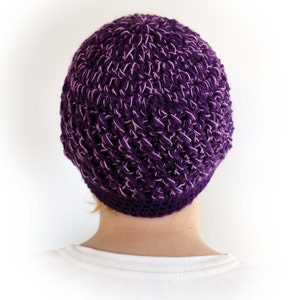 May include: A purple crocheted beanie hat with a textured pattern.