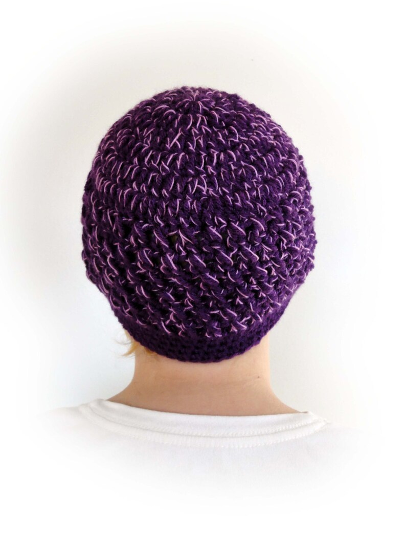 May include: A purple crocheted beanie hat with a textured pattern.