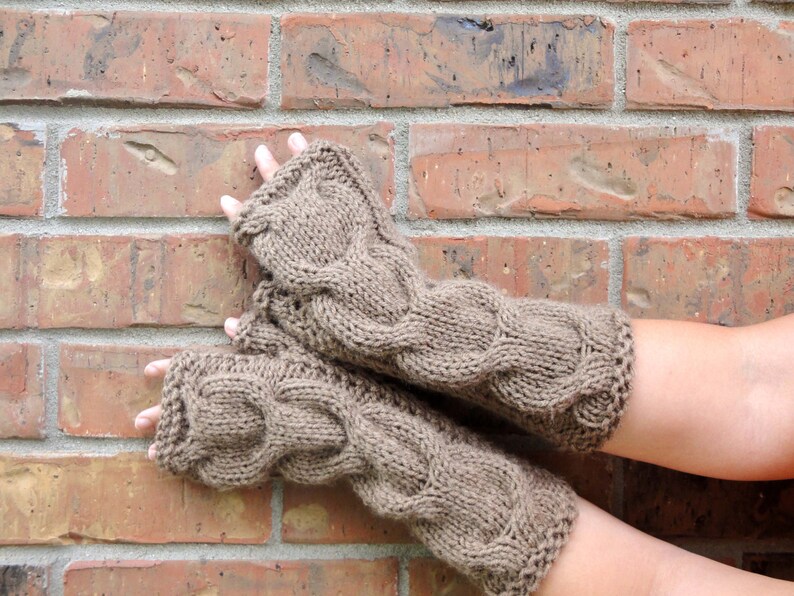 Puede incluir: Un par de guantes sin dedos de punto marr&oacute;n con un patr&oacute;n de trenza.
