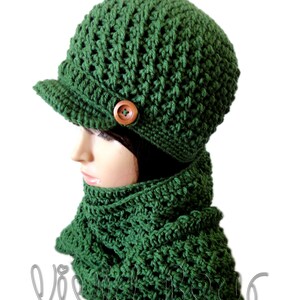 May include: A green crocheted hat with a brim and a wooden button. The hat is paired with a matching green crocheted scarf.