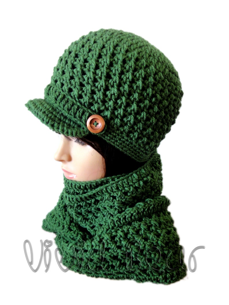 May include: A green crocheted hat with a brim and a wooden button. The hat is paired with a matching green crocheted scarf.