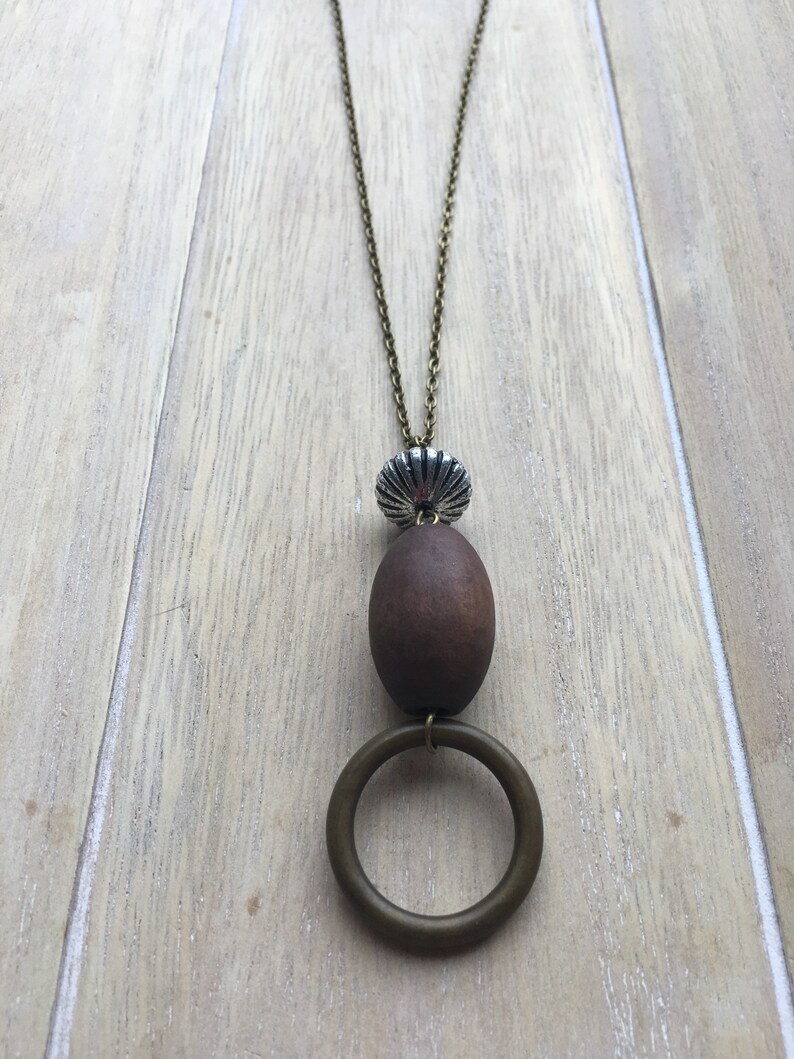 Long brown bronze colored necklace with beaded pendant.
