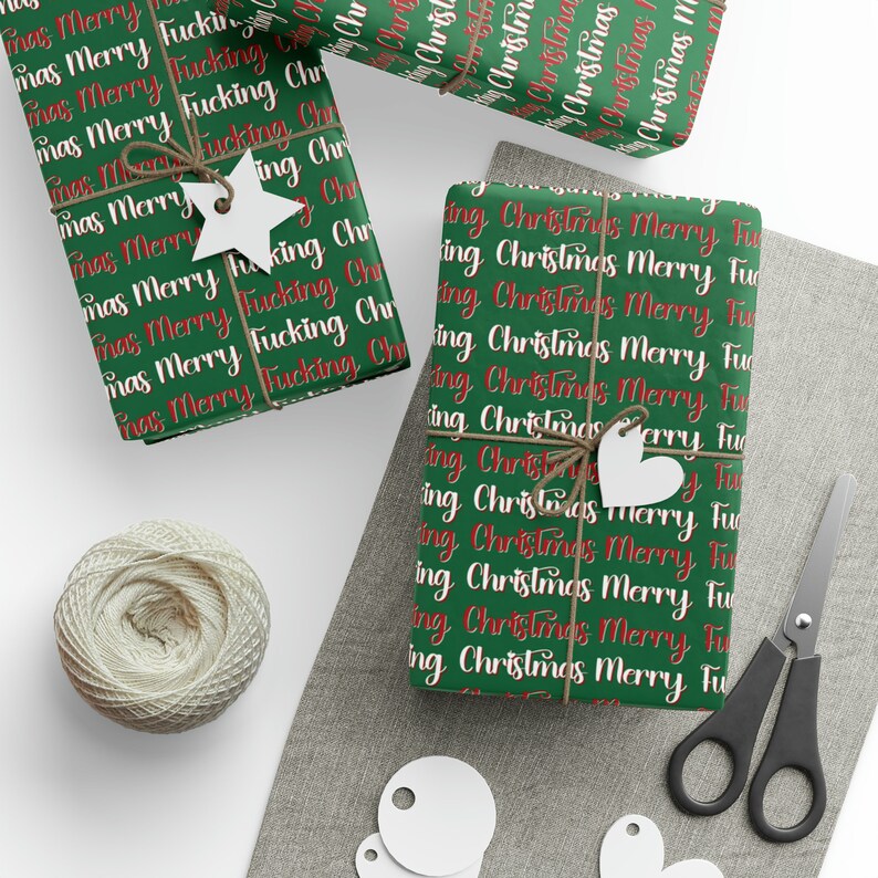 May include: Green wrapping paper with a repeating pattern of "Merry Christmas" and "Fucking Christmas" in red and white text.