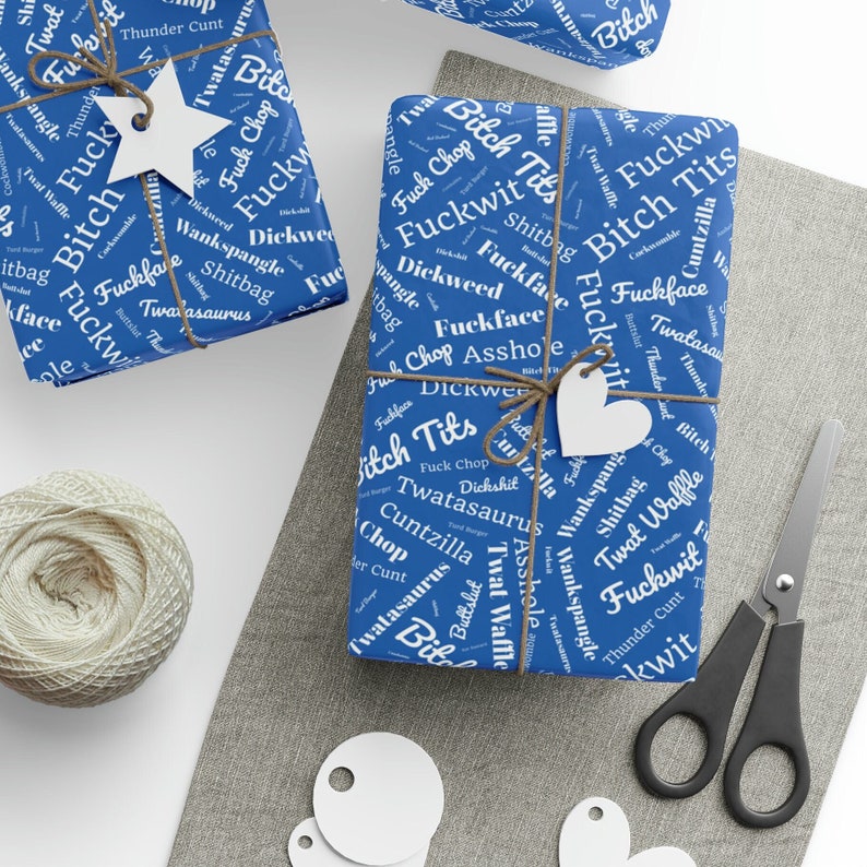 May include: Blue wrapping paper with a white pattern of words, including "Fuckwit", "Bitch Tits", "Dickweed", "Twat Waffle", and "Thunder Cunt".
